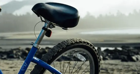 Bici con paisaje difuso de playa y ciudad al fondo
