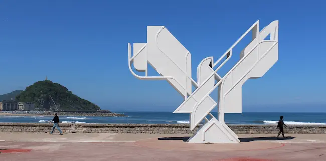 Escultura "La Paloma de la Paz" ubicada en la playa de Zurriola, en San Sebastián, representando un símbolo de esperanza y armonía, con el mar Cantábrico como fondo.