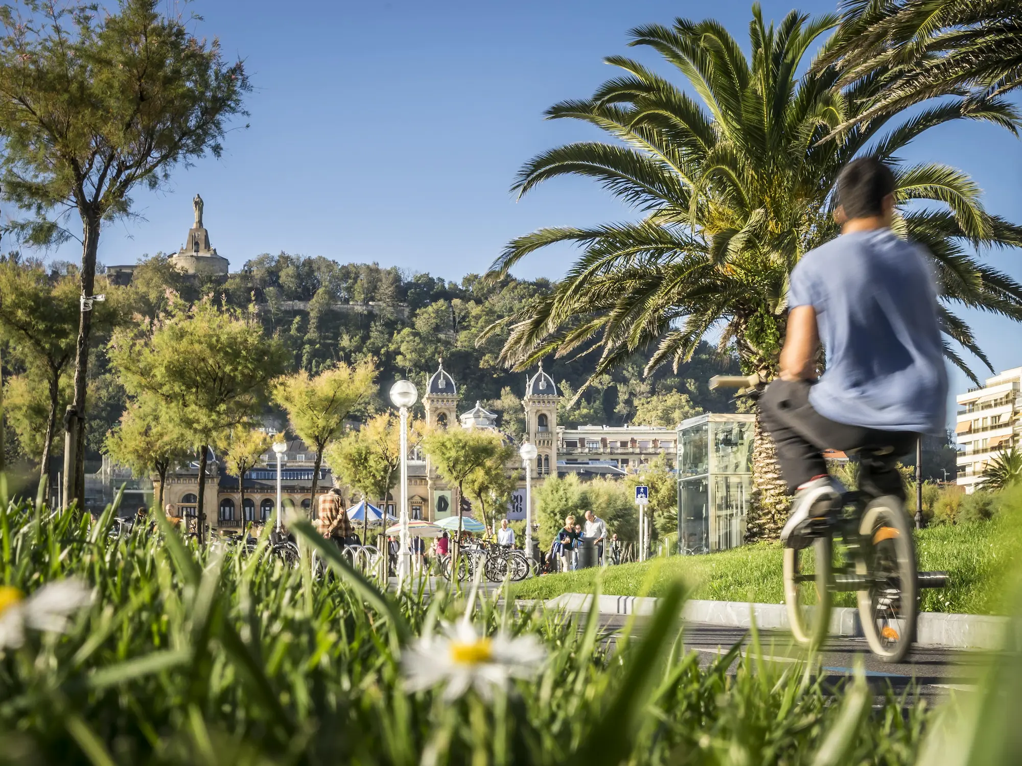 Joven andando en bicicleta por los jardines de Alderdi Eder, frente al Ayuntamiento