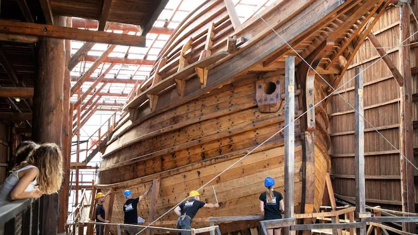 Personas trabajando en un barco de madera en Albaola.