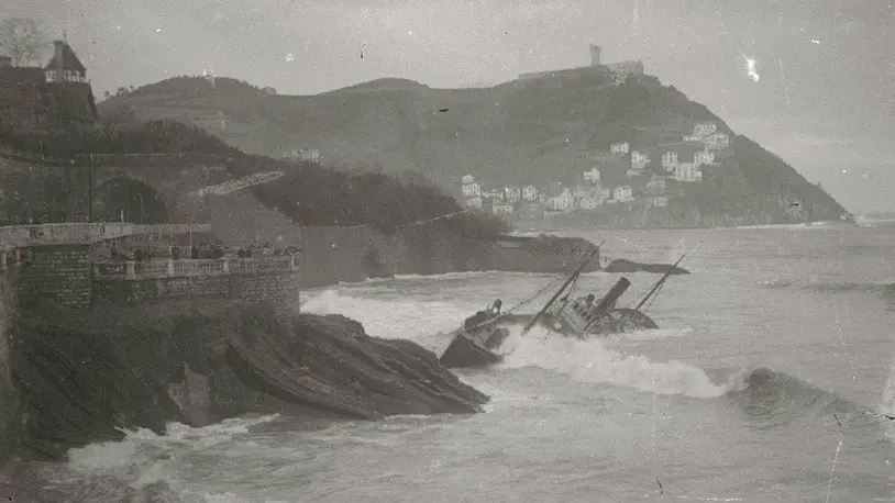 Imagen antigua de barco volcado en la bahía.