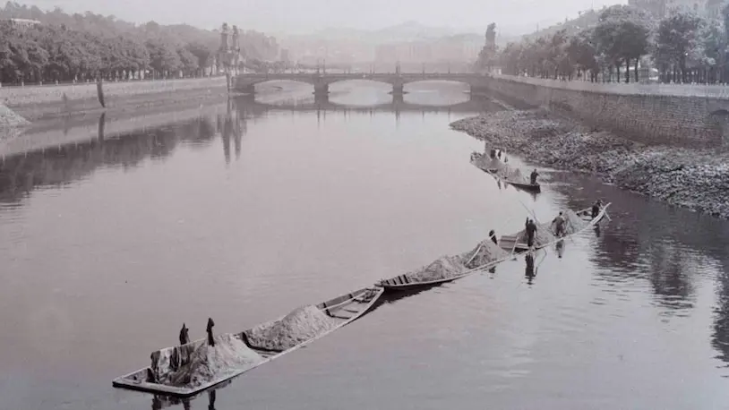 Foto en blanco y negro de personas en canoas navegando por el río Urumea