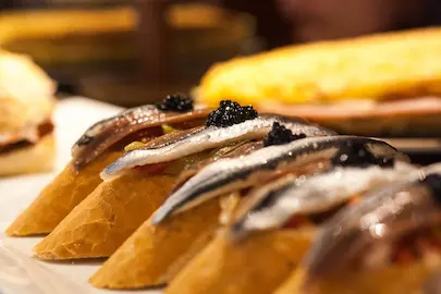 Pintxo de jamón, pimiento y anchoa: un bocado de sabor auténtico.