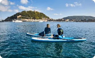 Chicas sentadas en la tabla de paddle surf