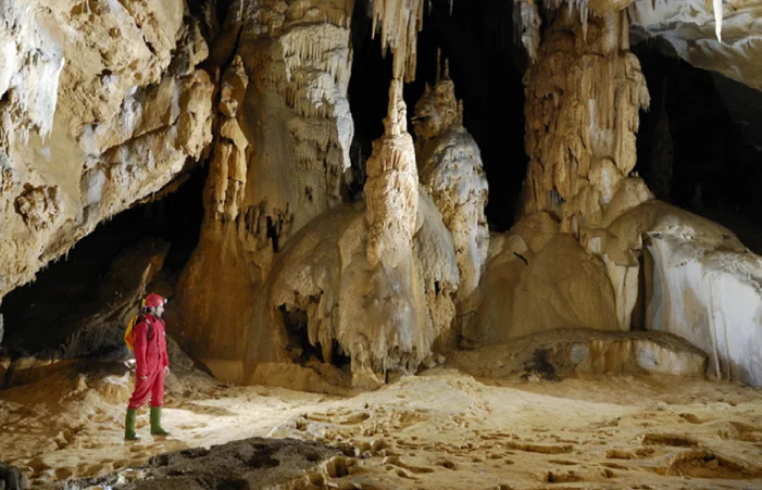 Espeleólogo explorando la Cueva de Arrikrutz en Oñati, con grandes formaciones geológicas.