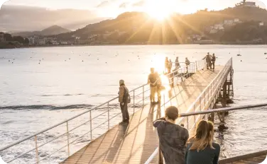 Pasarela junto al club náutico al atardecer, con gente paseando