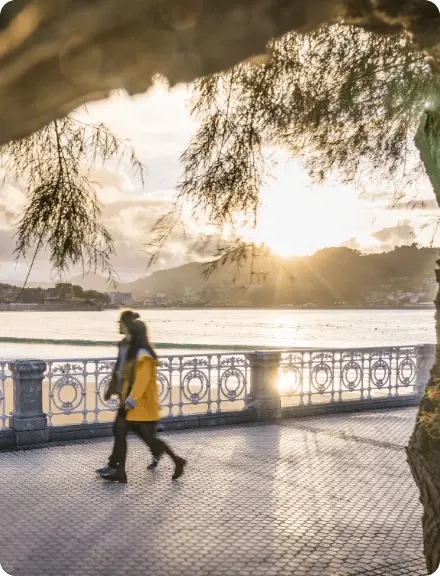 Gente paseando junto a La Concha al atardecer