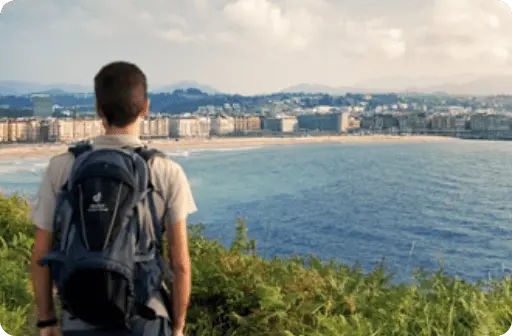 Senderista contemplando la costa de San Sebastián desde un alto